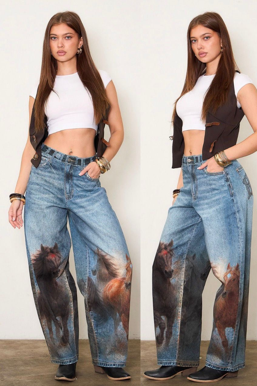 Three views of a model wearing high-waisted, wide-leg blue jeans with a printed horse design on the lower legs and 'COWBOY' embroidered on the back, shown against a plain indoor background.