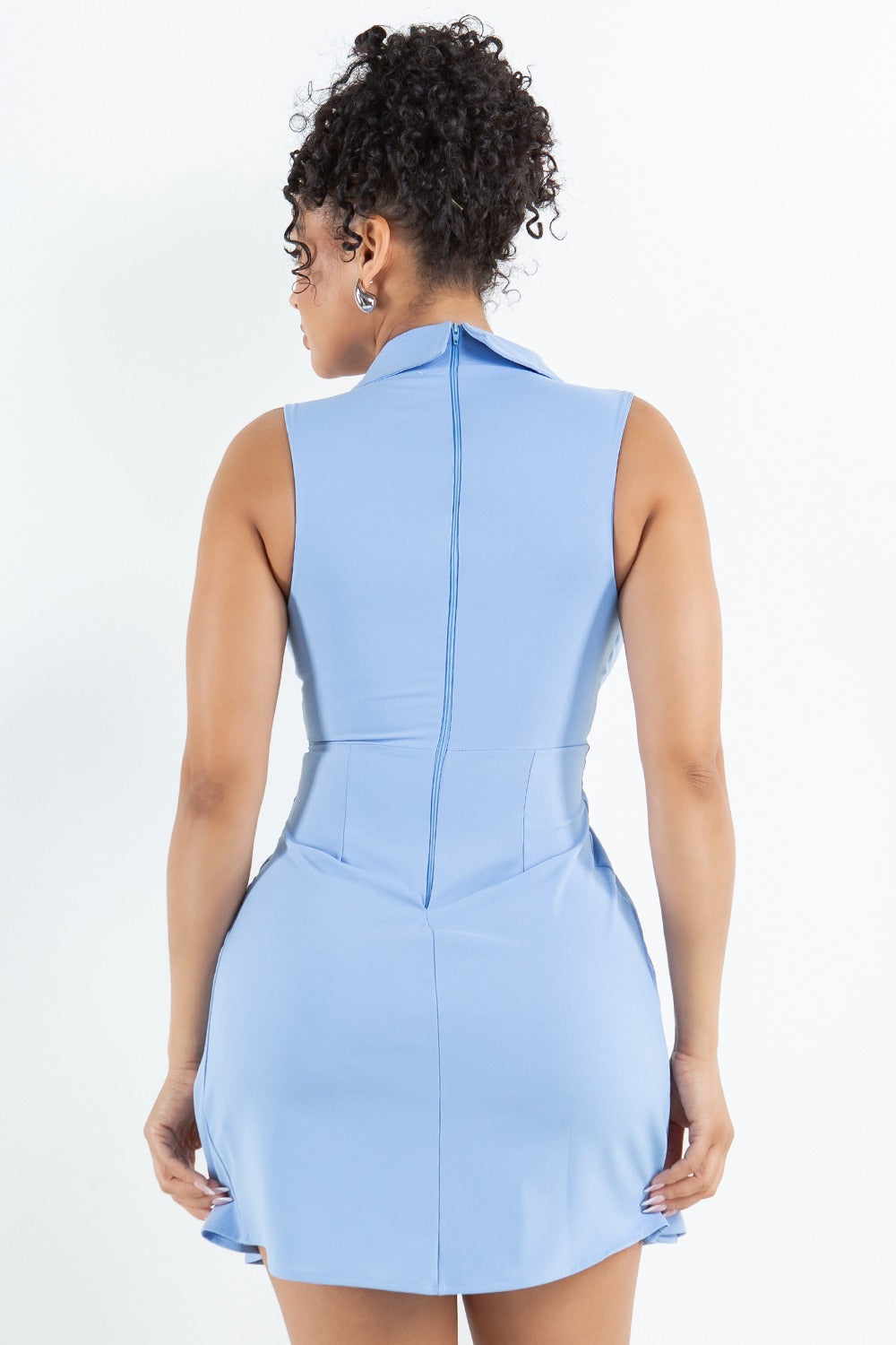 Woman wearing a light blue dress against a white background