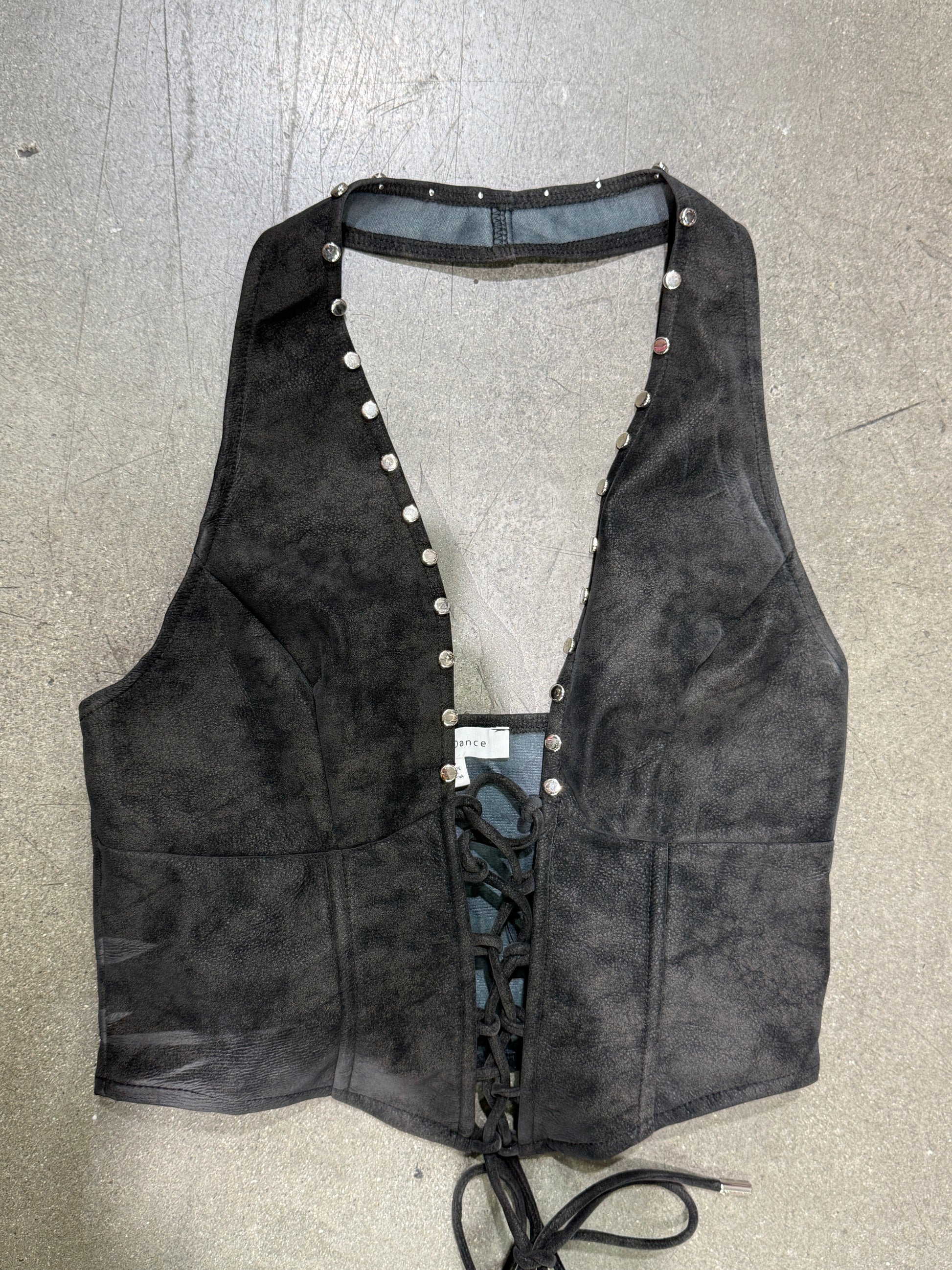 Black leather harness with studs on a gray surface