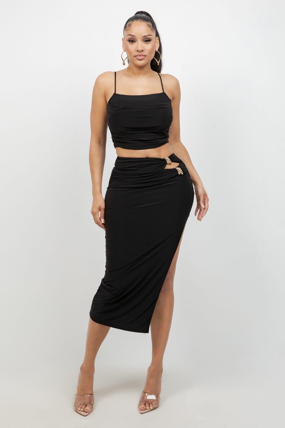 Woman wearing a black two-piece outfit with a white background
