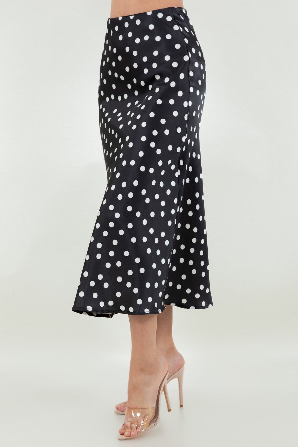 Black polka dot skirt worn by a person on a white background
