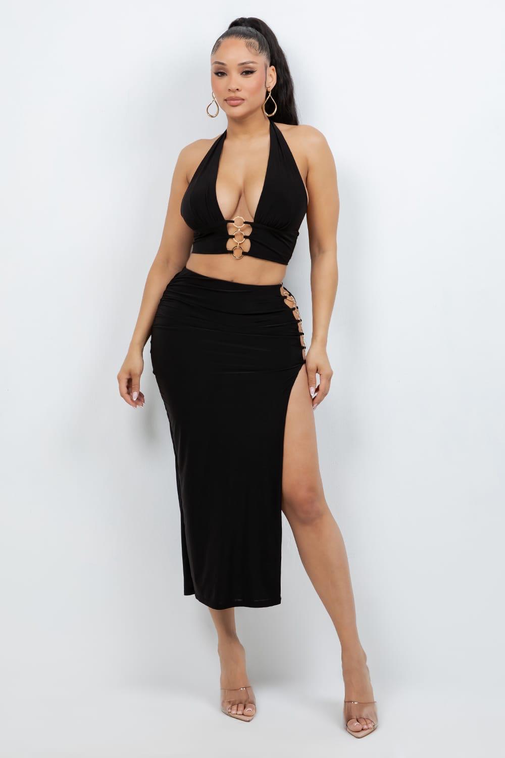 Woman wearing a black halter top and high-slit skirt on a white background