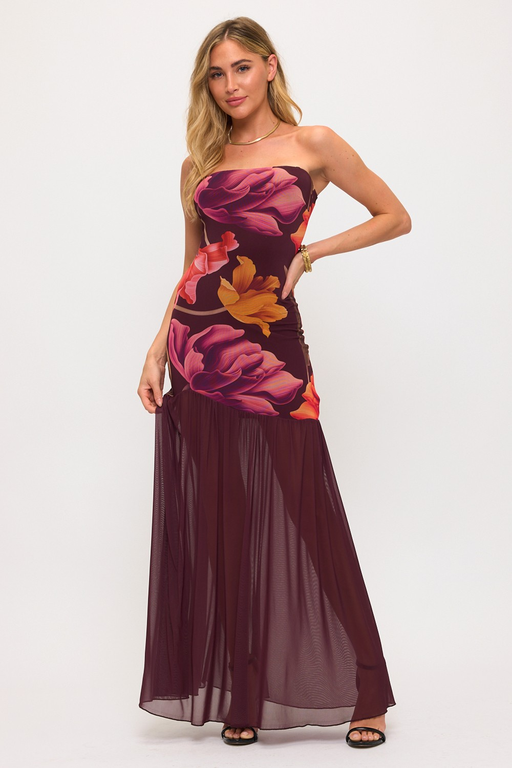 Woman wearing a strapless floral dress on a white background