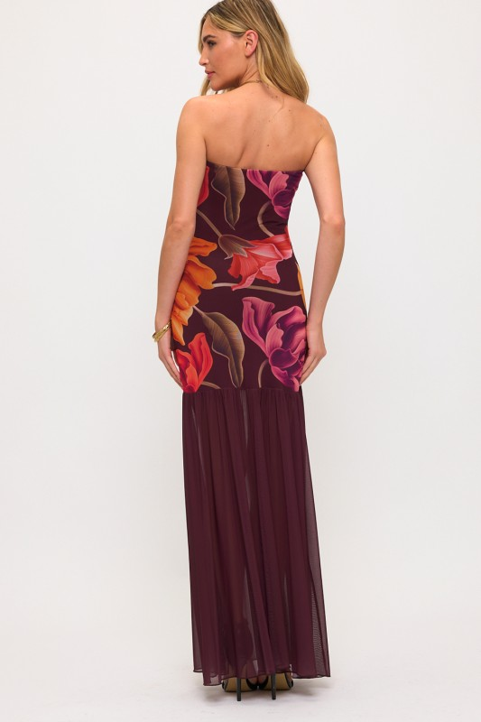 Woman wearing a strapless floral dress on a white background